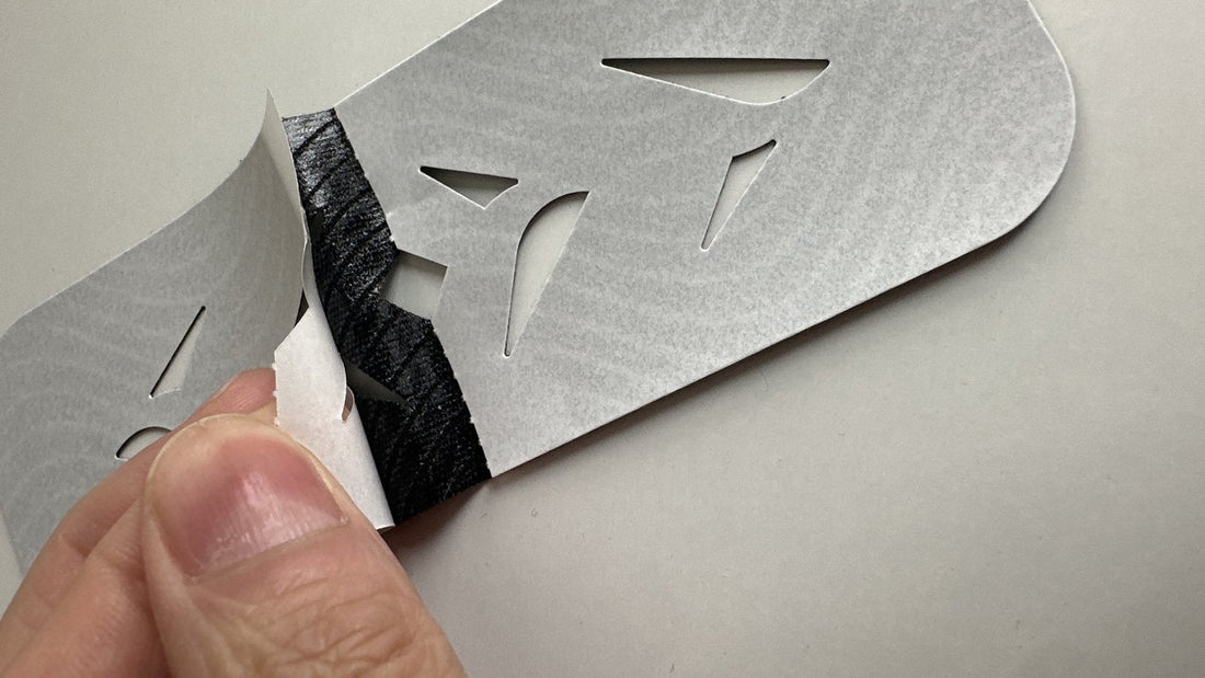 Cracking the die-cut paper backing off a pre-cut Easy Tape strip with a thumb fold