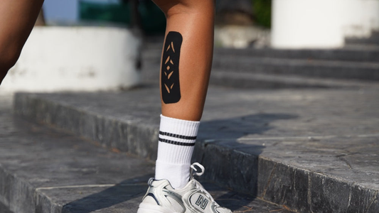 Climbing stone steps with a pre-cut kinesiology tape strip applied to the lower leg